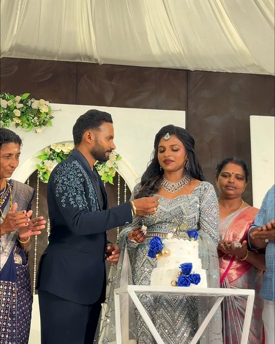 Couple cutting their wedding cake under a draped canopy