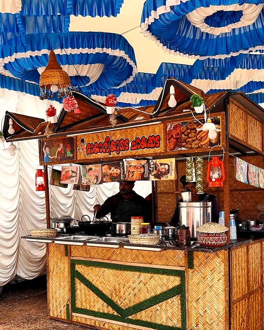 Hand-painted chai cart counter under a blue and white canopy