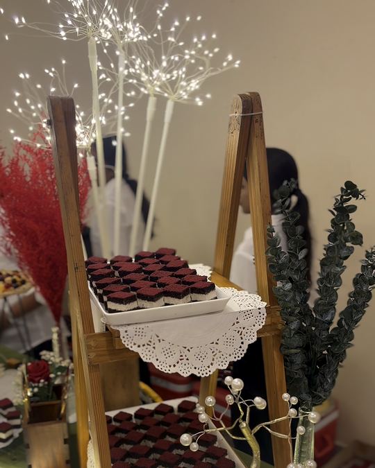Tiered dessert stand of chocolate cups with red pampas grass