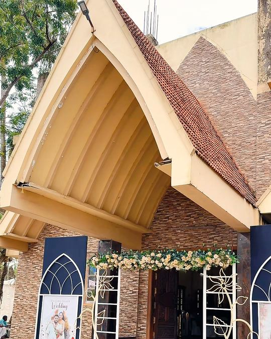 Gabled venue entrance dressed with florals and welcome boards