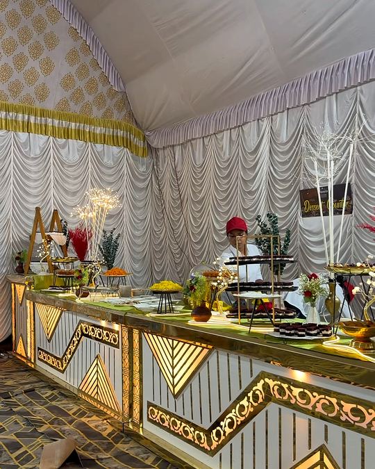 Gold and white buffet counter inside a draped event tent